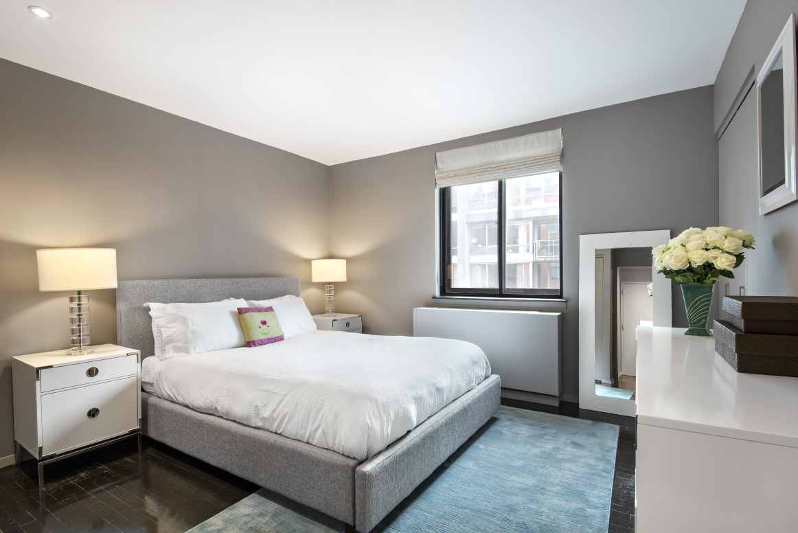 445 West 19th Street, Unit 6C Manhattan, NY 10011 - Photo 5 of 10 a bedroom with a bed and a chandelier