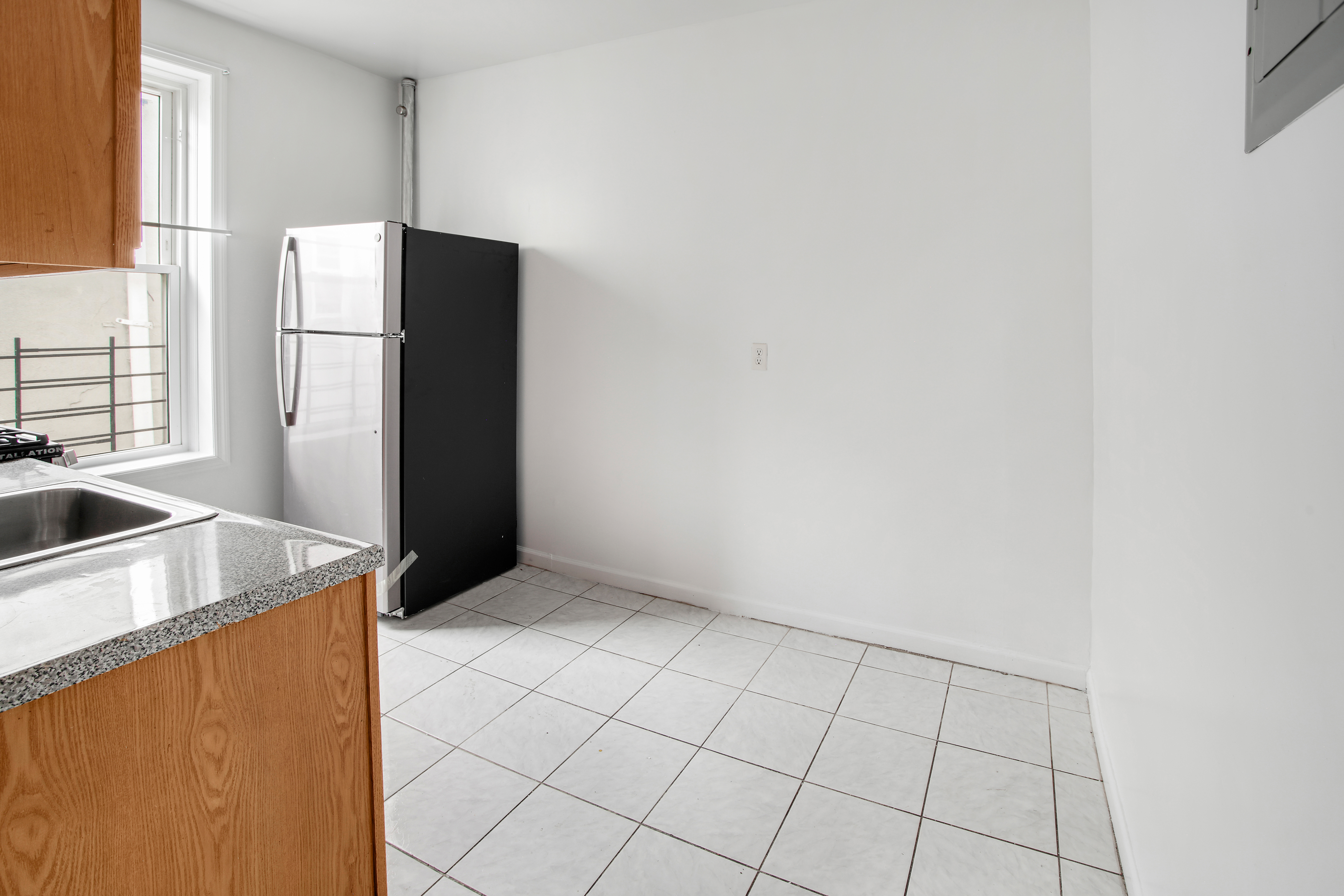 361 East 54th Street, Unit 2R Brooklyn, NY 11203 - Photo 2 of 9 a kitchen with a refrigerator sink and cabinets