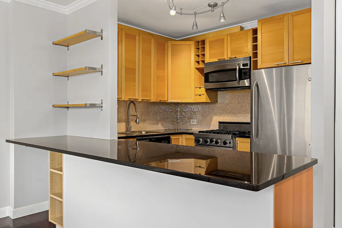 21 South End Avenue, Unit PH2BB Manhattan, NY 10280 - Photo 2 of 5 a kitchen with stainless steel appliances granite countertop a refrigerator a stove and a sink with wooden floor