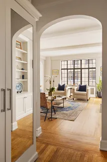 a living room with furniture and a floor to ceiling window