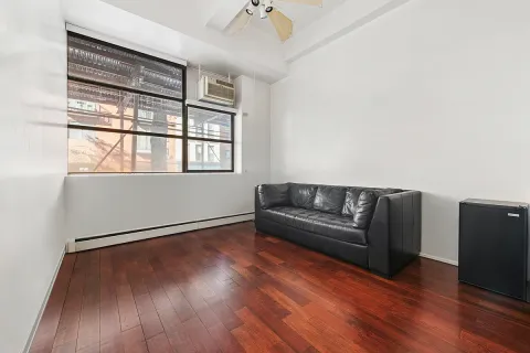 a living room with wooden floor and a window