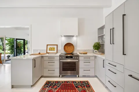 a stove top oven sitting inside of a kitchen