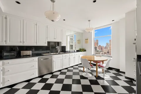 a kitchen with a checkered floor and white cabinets