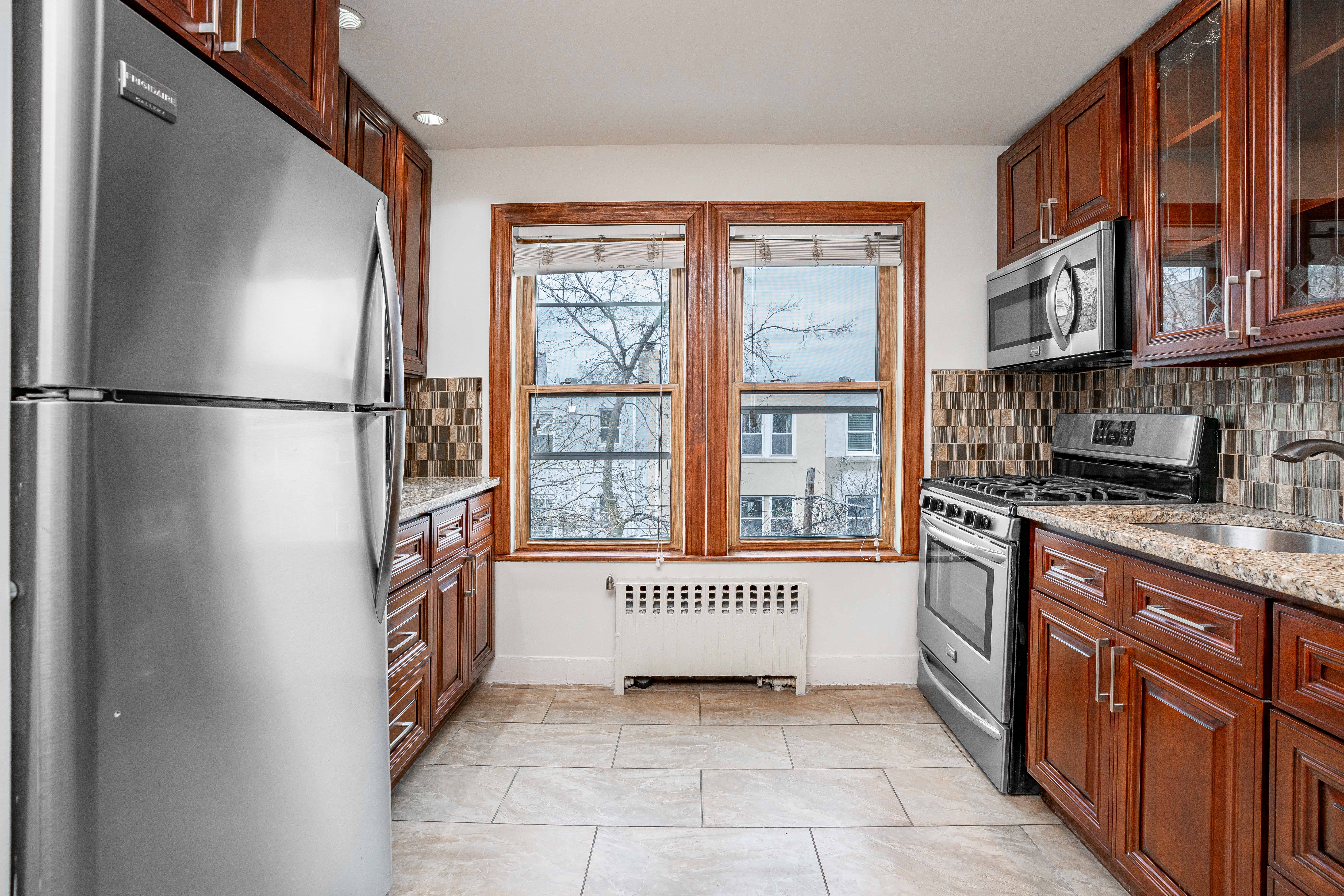 20-60 33rd Street, Unit 2 Queens, NY 11105 - Photo 5 of 10 a kitchen with stainless steel appliances granite countertop a refrigerator and a sink