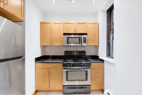 a kitchen with stainless steel appliances a stove microwave and sink