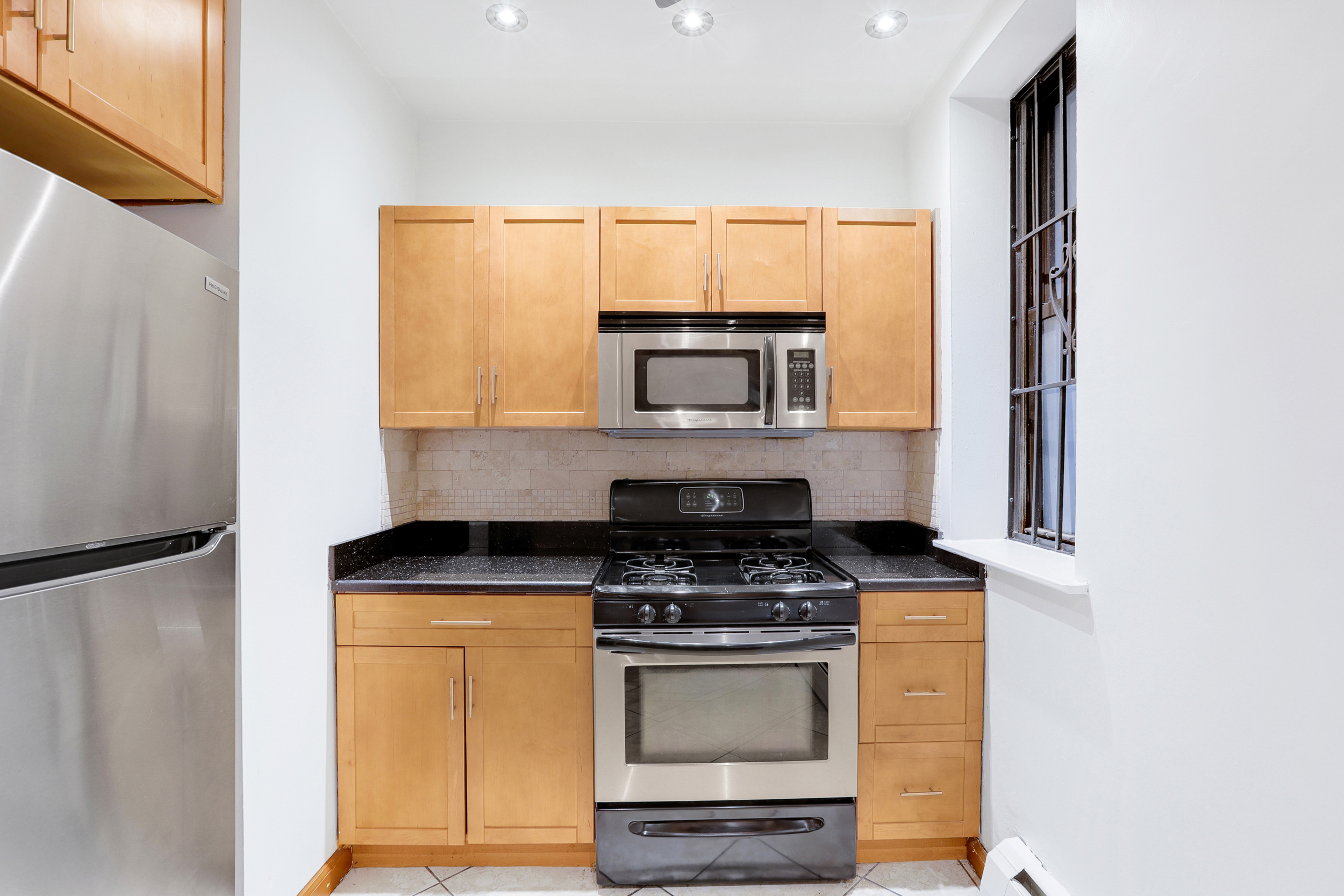 66-72 St Nicholas Avenue, Unit 3G Manhattan, NY 10026 - Photo 6 of 15 a kitchen with stainless steel appliances a stove microwave and sink