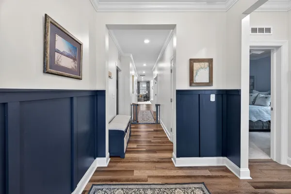 a view of a hallway with wooden floor and staircase