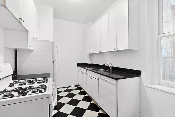 50 East 96th Street, Unit 2A Manhattan, NY 10128 - Photo 3 of 7 a kitchen with granite countertop a sink stove and refrigerator