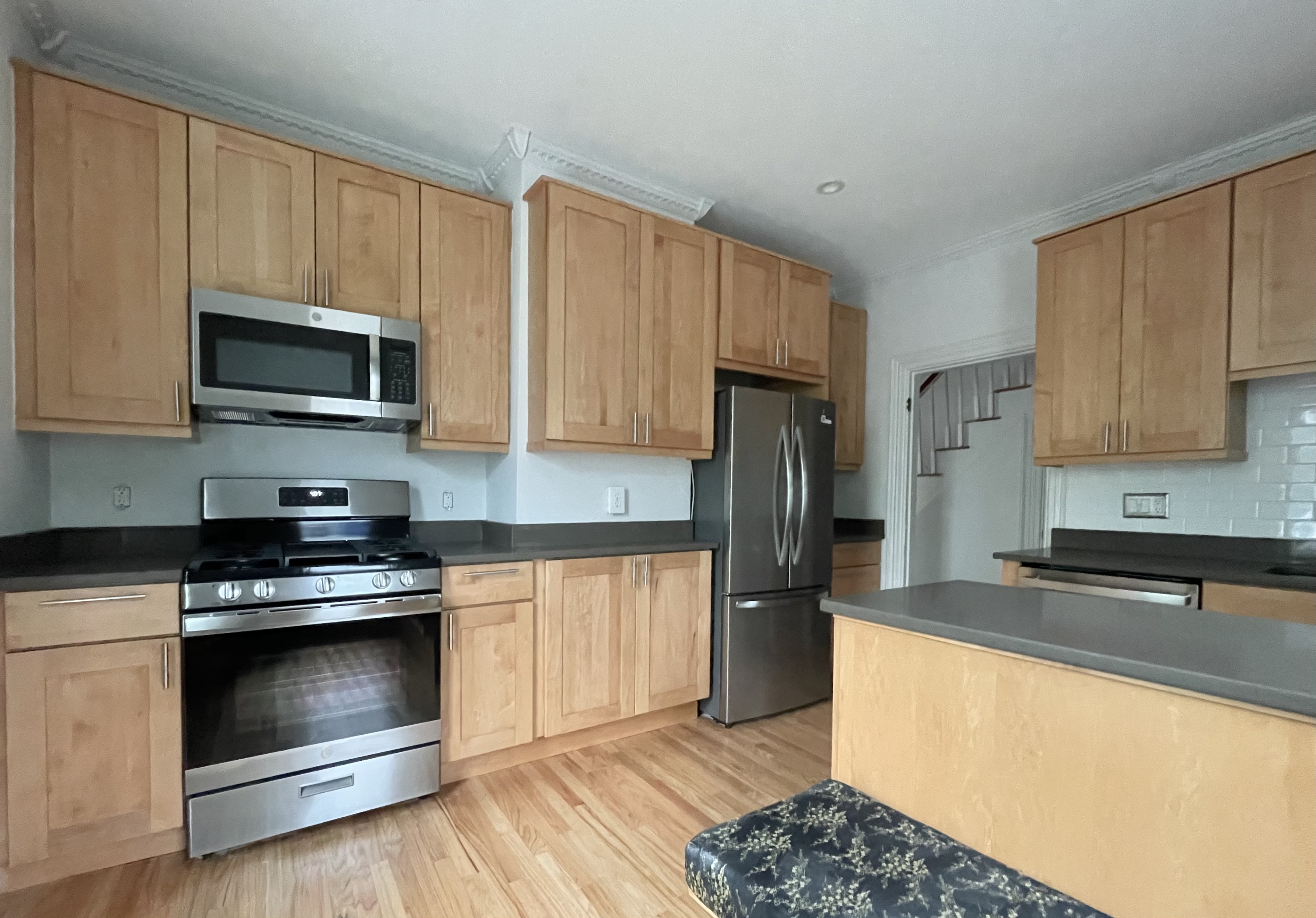 49 8th Street Cambridge, MA 02141 - Photo 2 of 6 a kitchen with granite countertop wooden cabinets stainless steel appliances and a window