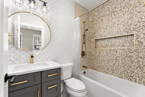 a bathroom with a sink a toilet and shower