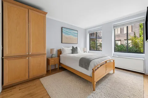 a bed sitting in a bedroom next to a window