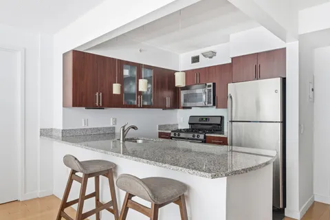 a kitchen with stainless steel appliances granite countertop a sink refrigerator and microwave