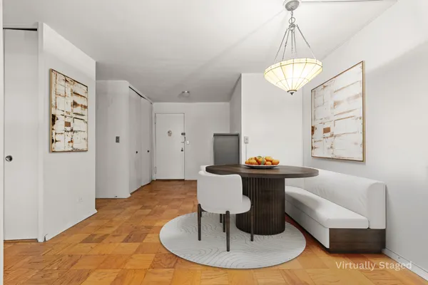 a living room with dining table and a chandelier