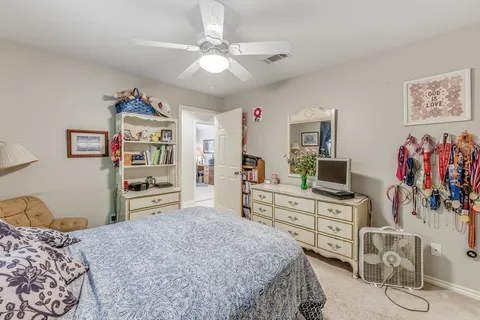 a bedroom with a large bed and a flat tv screen on dresser