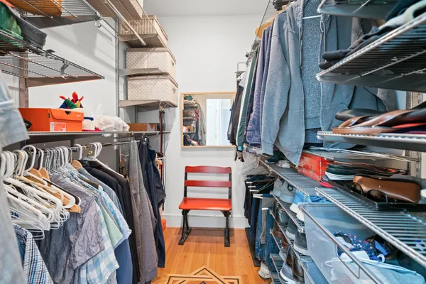 a view of walk in closet with clothes and shoes