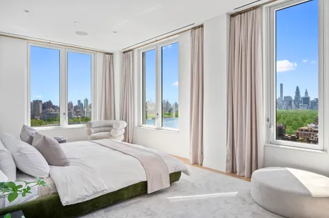 a bedroom with a bed and a large window