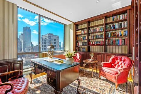 a living room with furniture a rug and a book shelf