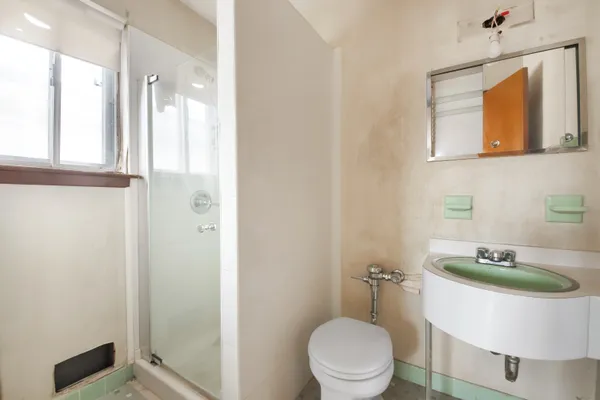 a bathroom with a toilet a sink and shower