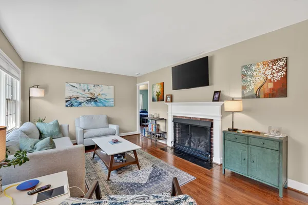 a living room with furniture a flat screen tv and a fireplace