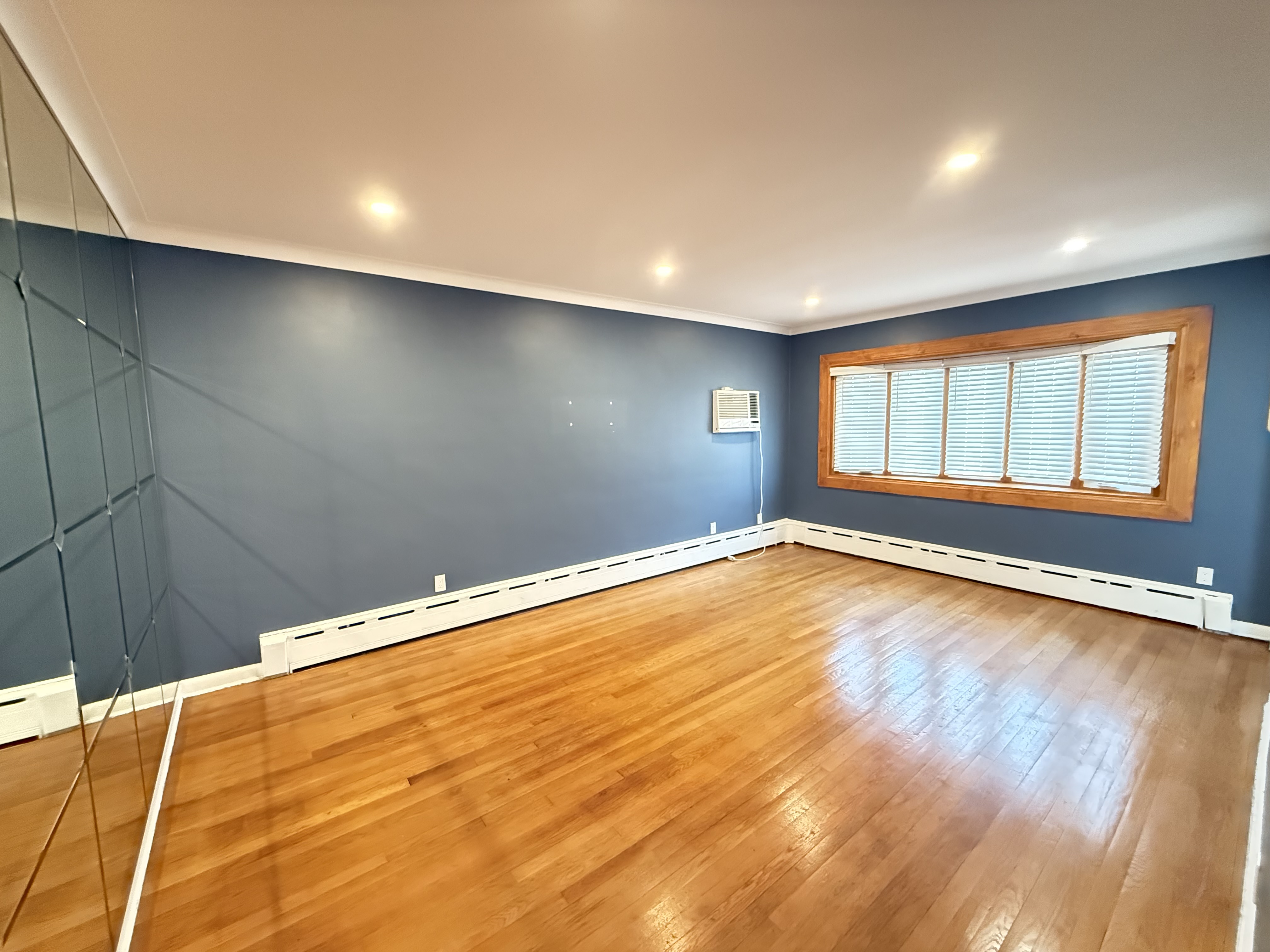 3236 Country Club Road Bronx, NY 10465 - Photo 8 of 22 a view of empty room with wooden floor and fan
