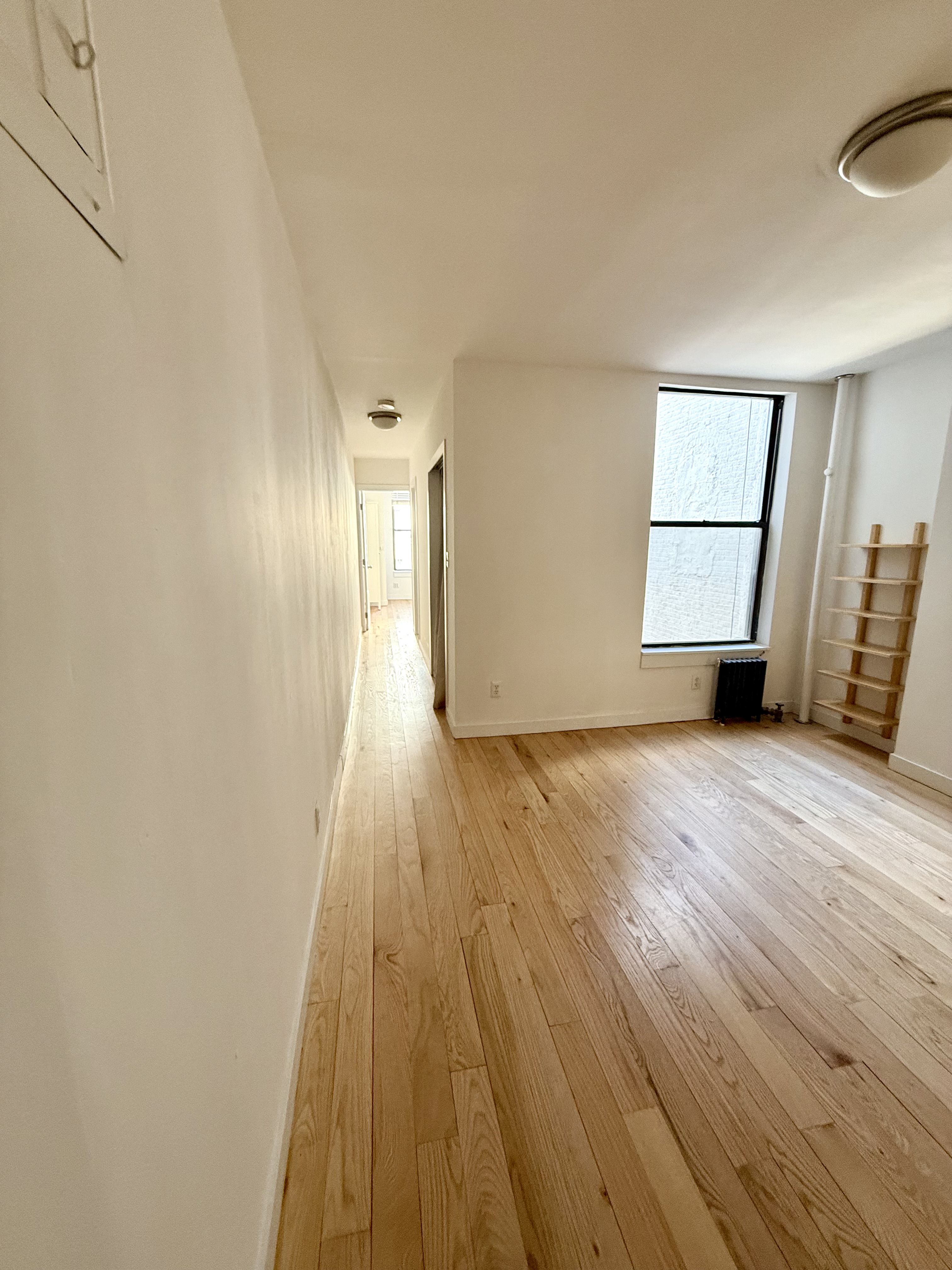 245 West 115th Street, Unit 16 Manhattan, NY 10026 - Photo 5 of 10 a view of empty room with wooden floor and fan