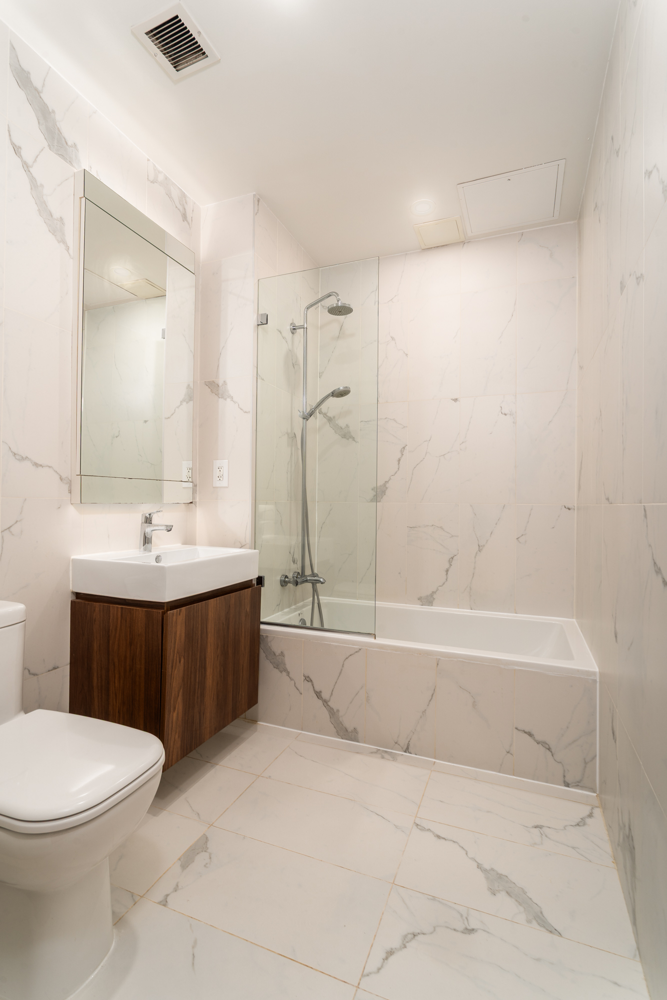 21 Powers Street, Unit 3A Brooklyn, NY 11211 - Photo 9 of 14 a bathroom with a bathtub a sink a toilet and a mirror