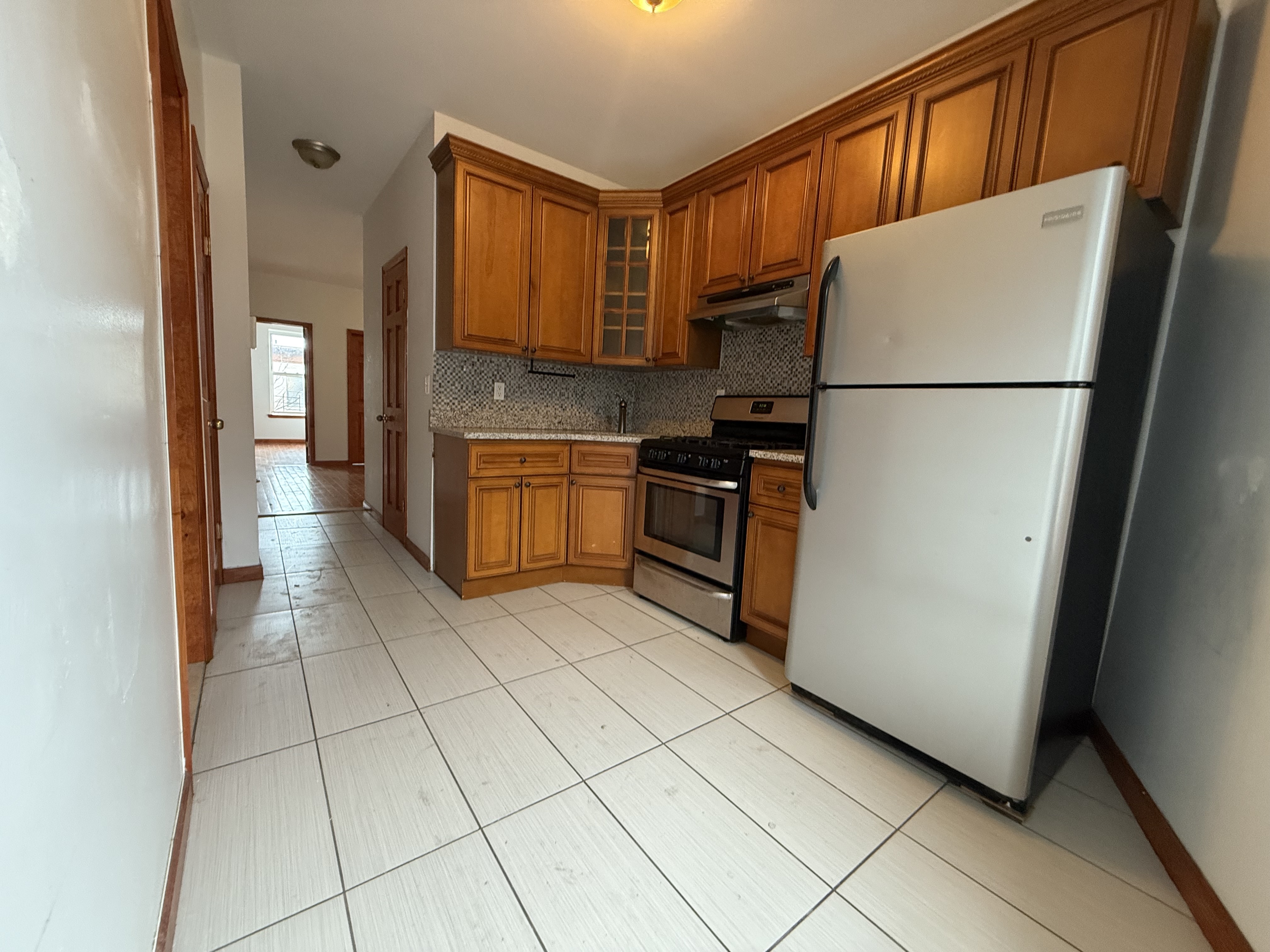 386 Prospect Place Brooklyn, NY 11238 - Photo 4 of 7 a kitchen with granite countertop a refrigerator a stove top oven and cabinets