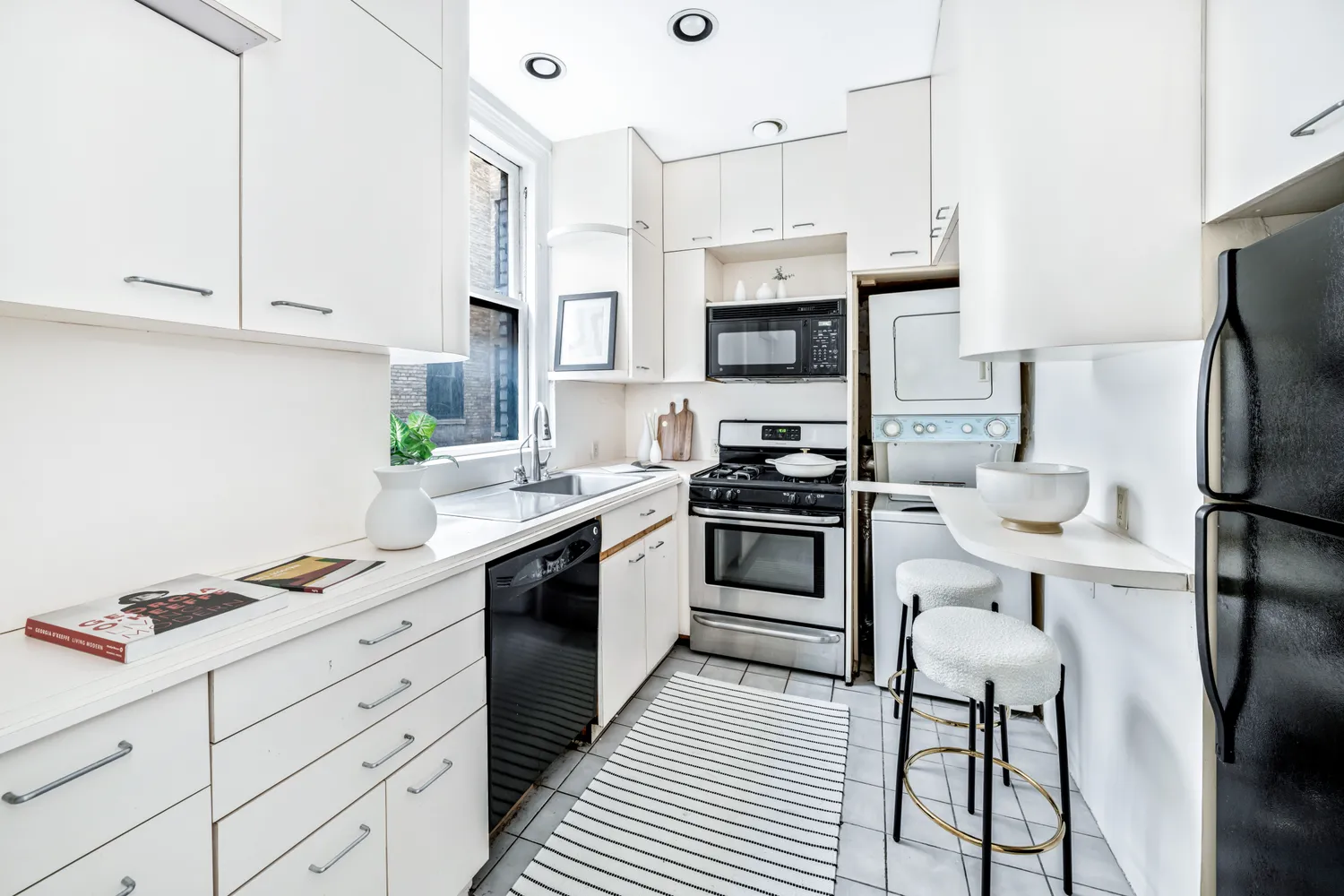 a kitchen with stainless steel appliances a refrigerator sink and white cabinets