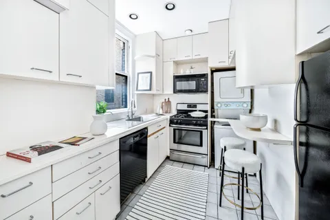 a kitchen with stainless steel appliances a refrigerator sink and white cabinets