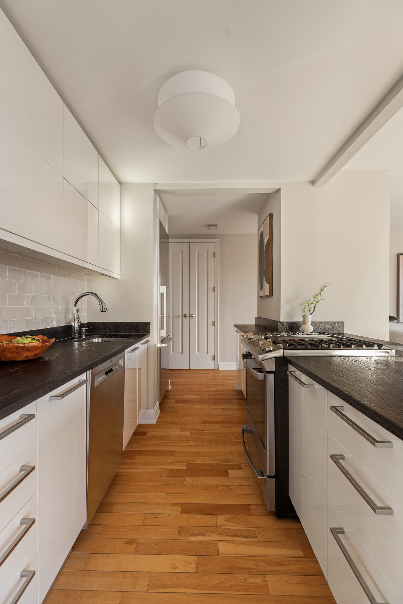 1438 3rd Avenue, Unit 15B Manhattan, NY 10028 - Photo 7 of 21 a kitchen with stainless steel appliances granite countertop a stove and a sink