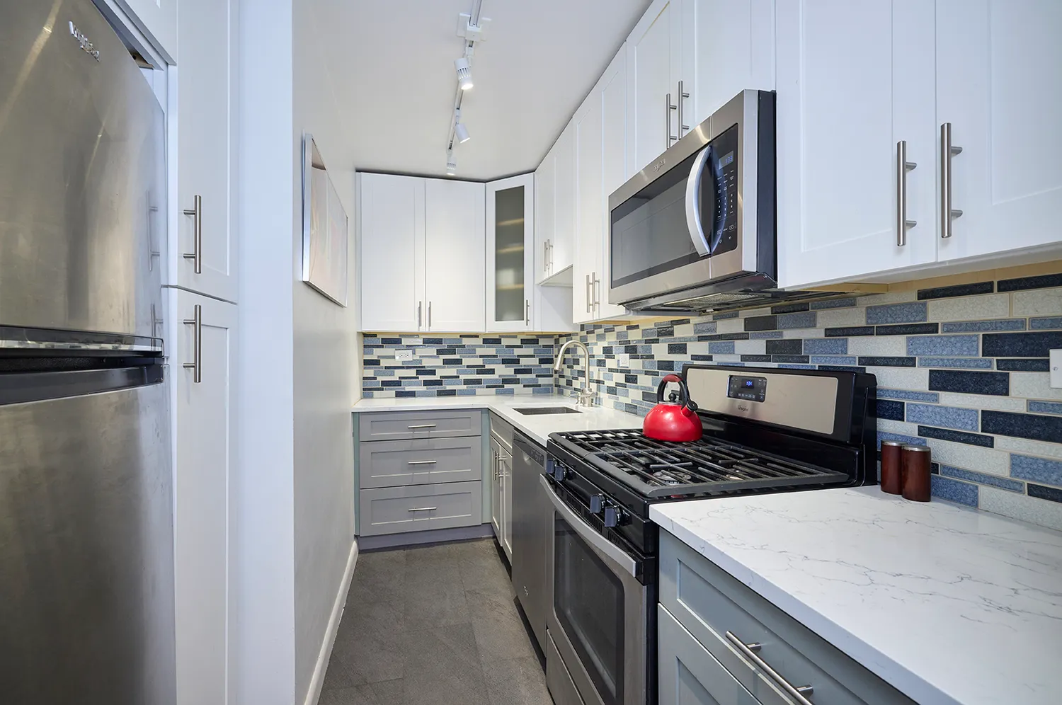 a kitchen with stainless steel appliances granite countertop a stove and a microwave