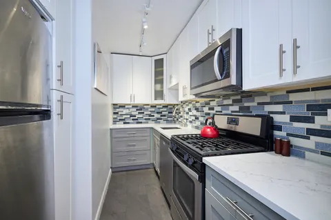 a kitchen with stainless steel appliances granite countertop a stove and a microwave