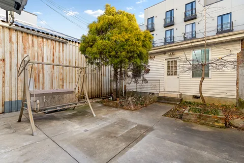 a backyard of a house with chairs and tables