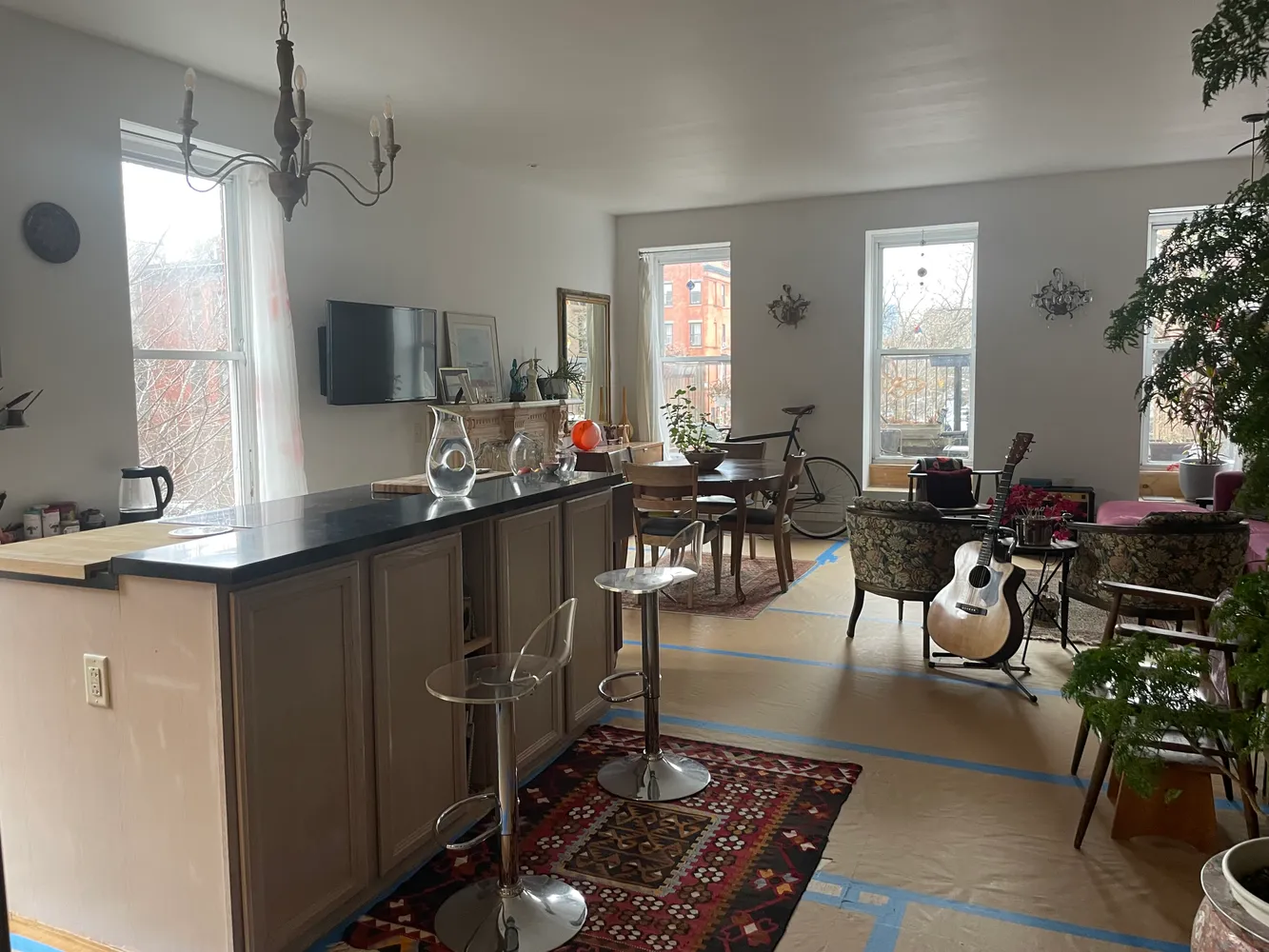 a living room with furniture a large window and a chandelier