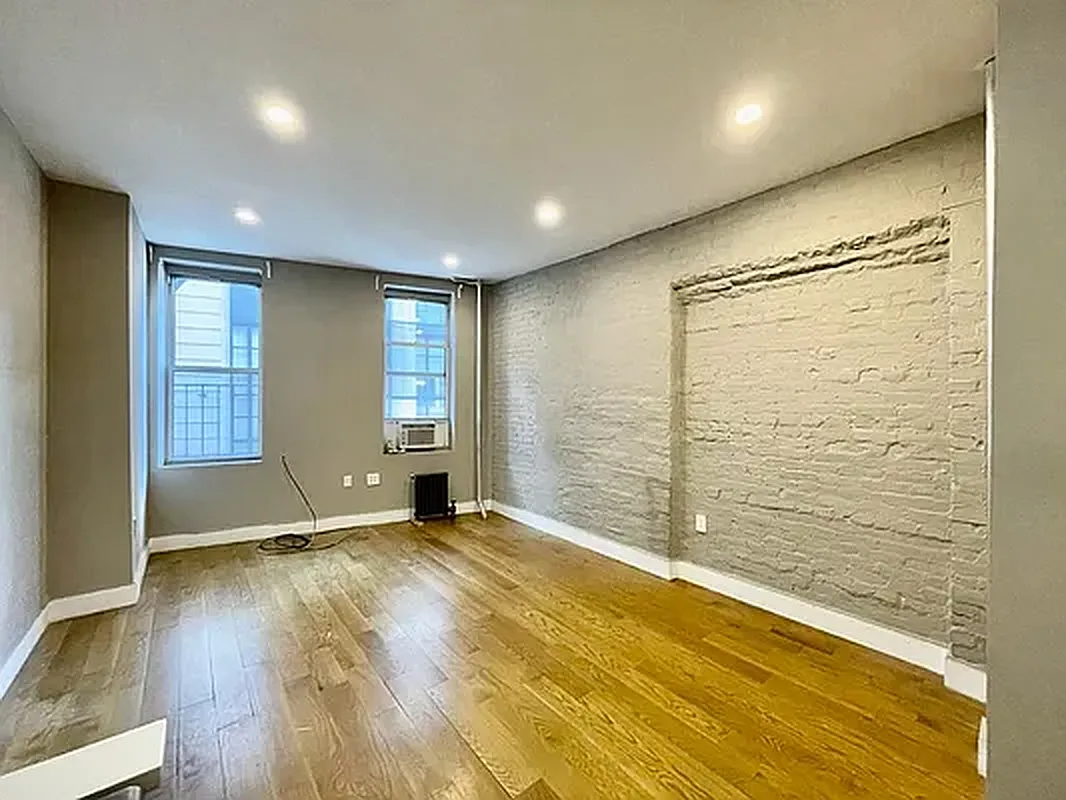 57 Spring Street, Unit 2 Manhattan, NY 10012 - Photo 2 of 5 a view of an empty room with wooden floor and a window