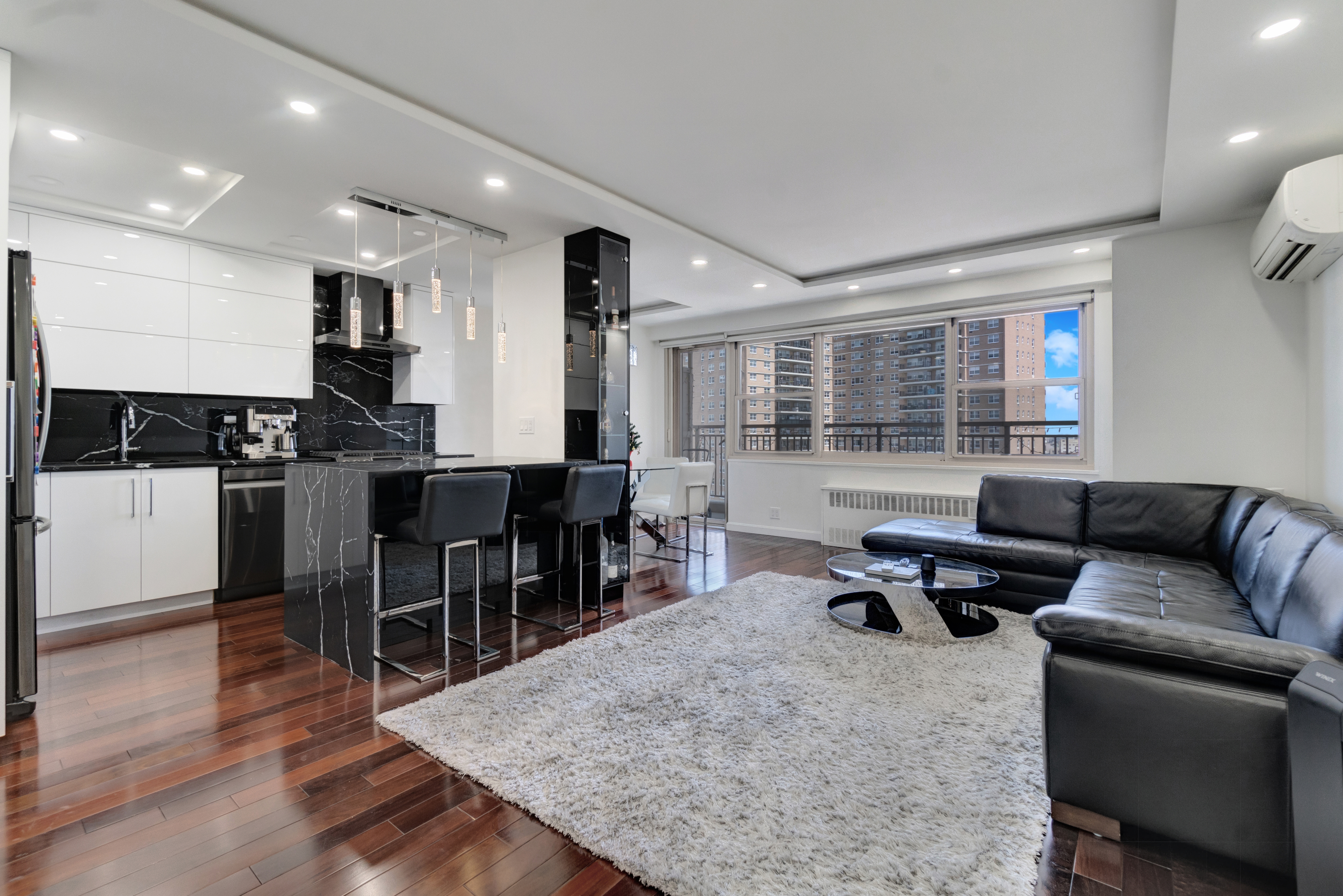 448 Neptune Avenue, Unit 14L Brooklyn, NY 11224 - Photo 1 of 20 a living room with furniture a wooden floor and kitchen view