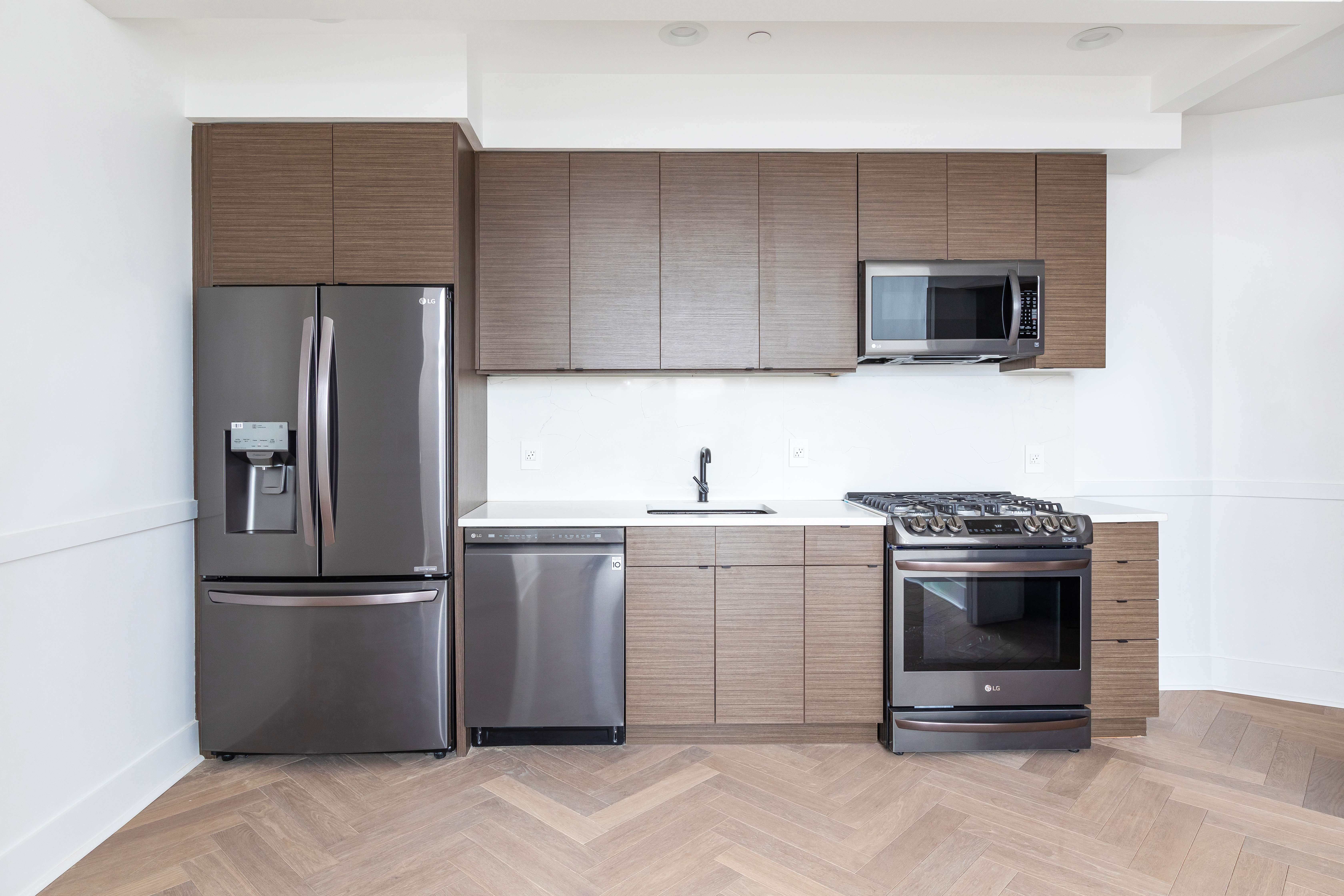 47-16 Greenpoint Avenue, Unit 3A Queens, NY 11104 - Photo 5 of 9 a kitchen with a sink stainless steel appliances and cabinets