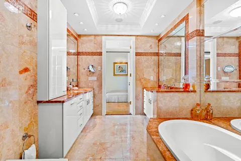 a spacious bathroom with a tub sink and mirror