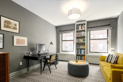 a living room with furniture a chandelier and a window