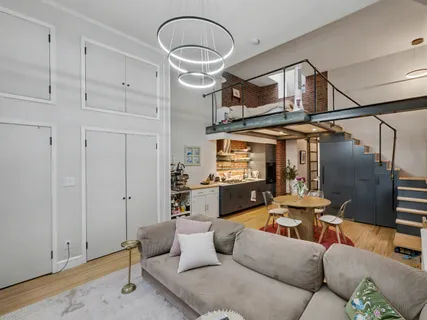 a living room with furniture a fireplace and a ceiling fan