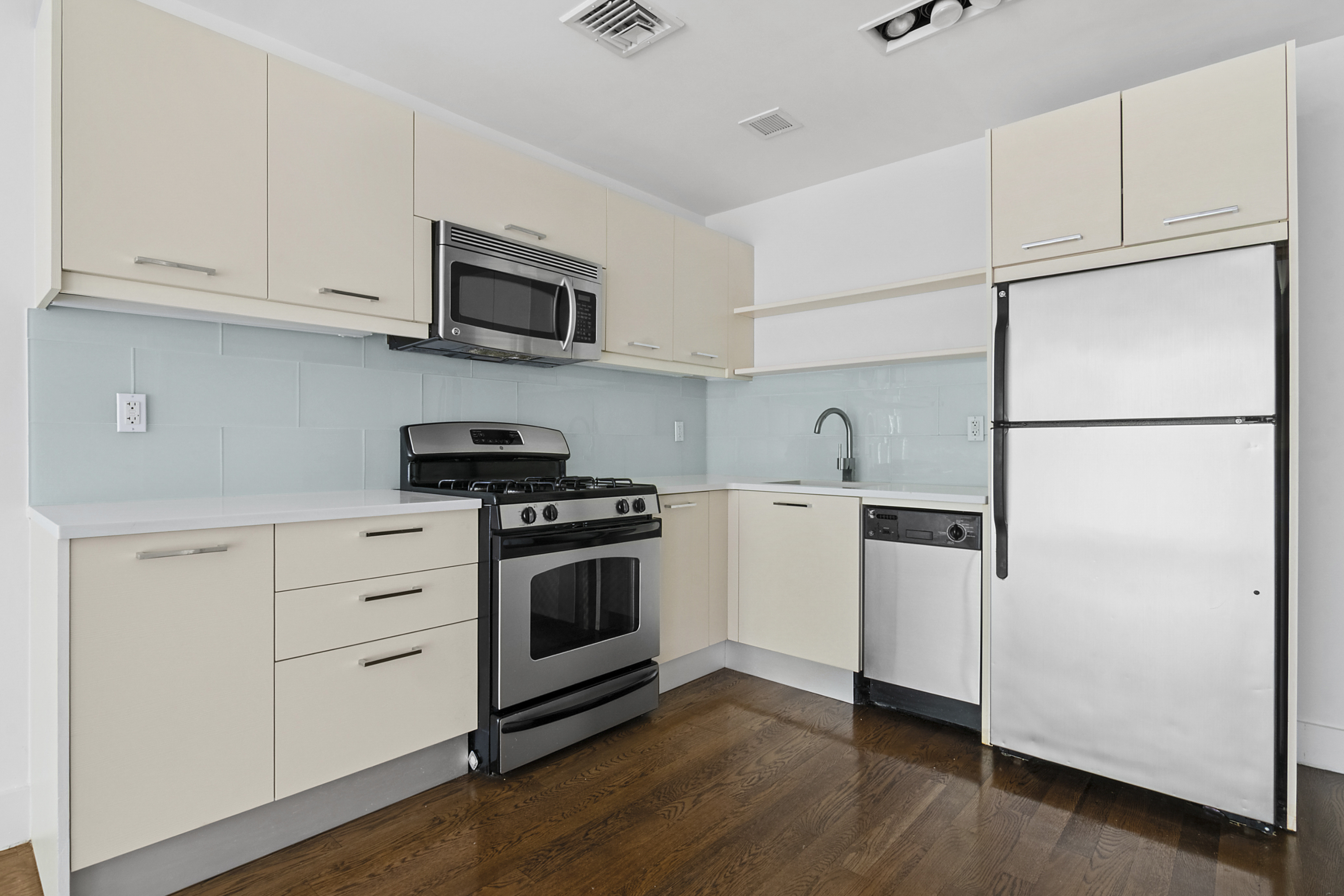 238 Saint Marks Avenue, Unit 2A Brooklyn, NY 11238 - Photo 3 of 6 a kitchen with white cabinets and white appliances