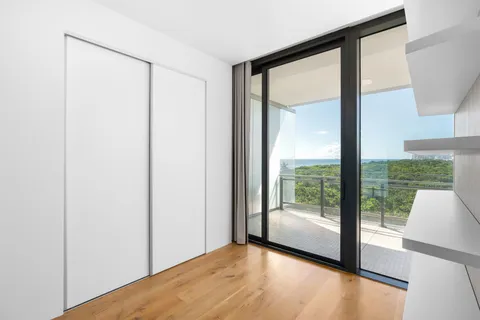 a view of an empty room with wooden floor and a floor to ceiling window