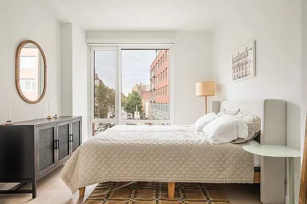 975 Nostrand Avenue, Unit 632 Brooklyn, NY 11225 - Photo 4 of 14 a bedroom with a bed and a large mirror on the dresser