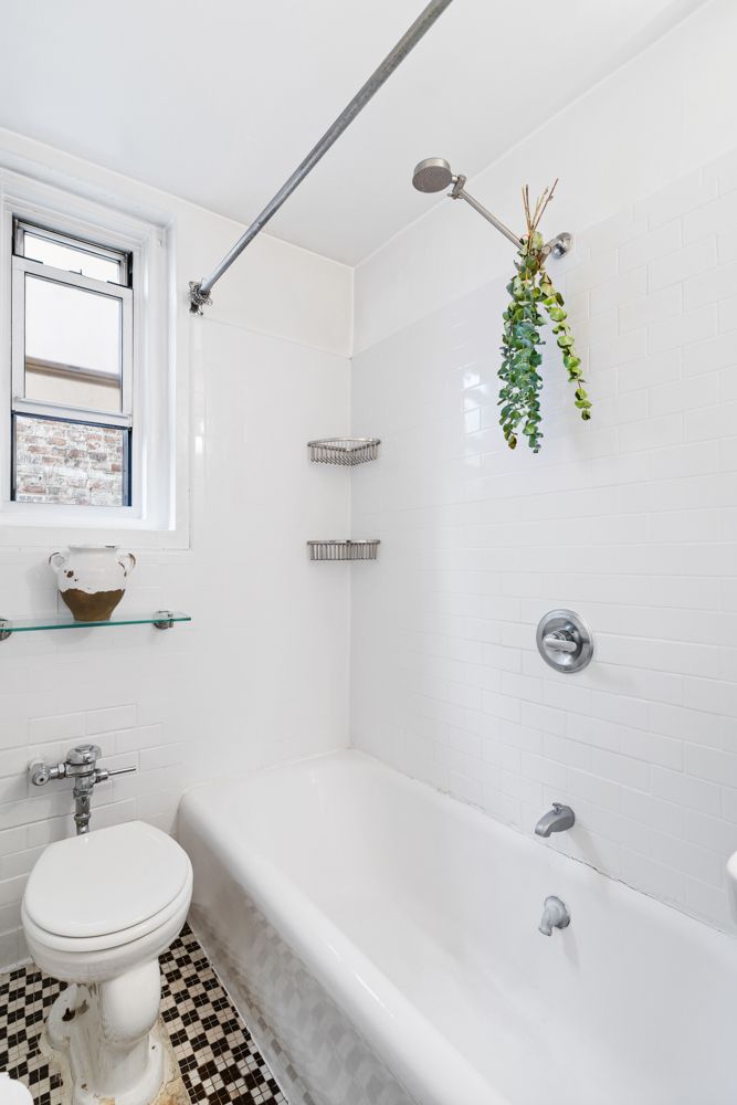 104 Bedford Street, Unit 4C Manhattan, NY 10014 - Photo 6 of 9 a bathroom with a sink a toilet and shower