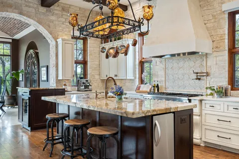 a kitchen with granite countertop a stove and a white cabinet