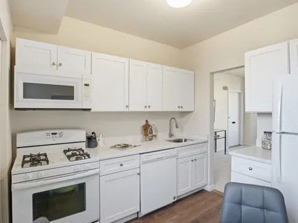 a kitchen with cabinets appliances a sink and a counter space