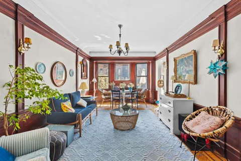 a living room with furniture chandelier and a large window