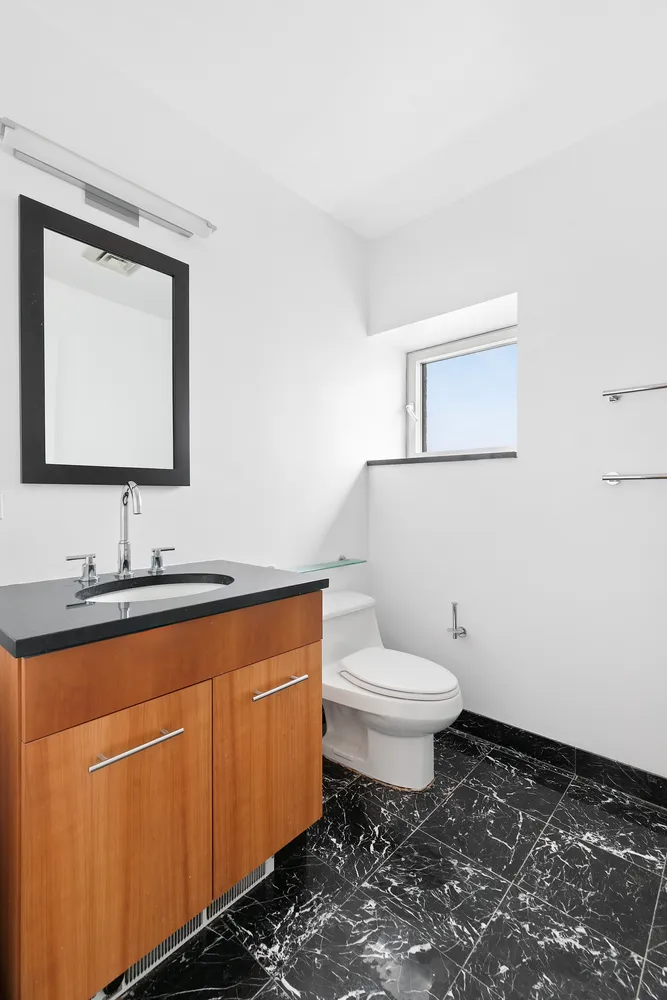 a bathroom with a toilet sink and mirror
