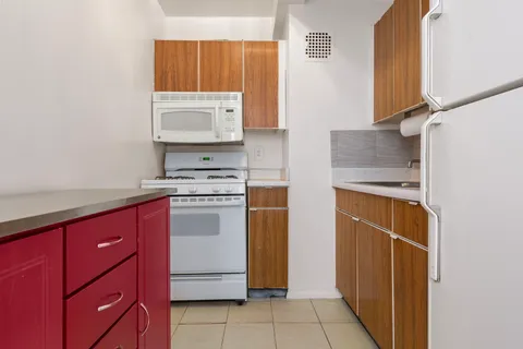 a kitchen with a refrigerator sink and cabinets