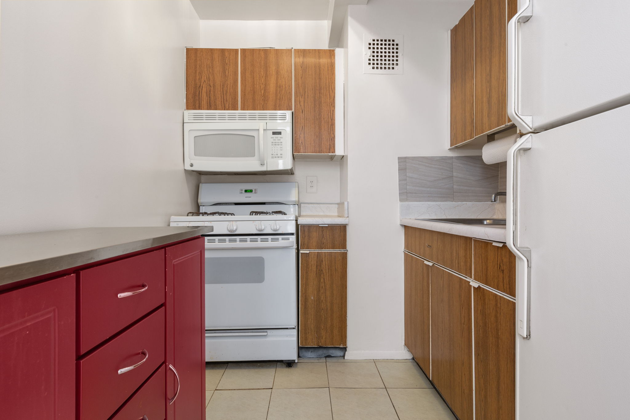 107-40 Queens Boulevard, Unit 16G Queens, NY 11375 - Photo 5 of 6 a kitchen with a refrigerator sink and cabinets